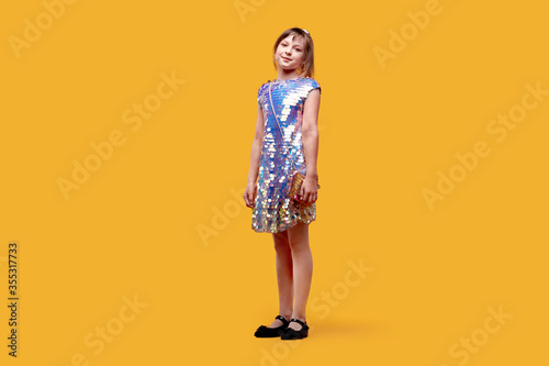 In full height smiling dancing cute girl looks into the camera. Holiday dress
