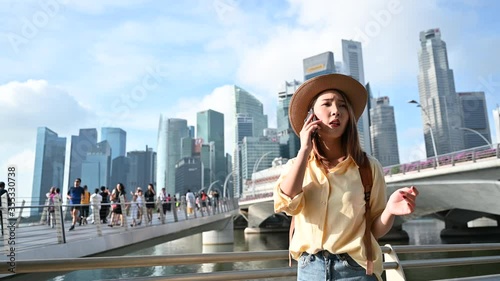 Young Asian woman calling phone looking for location of appointment in Singapore city 