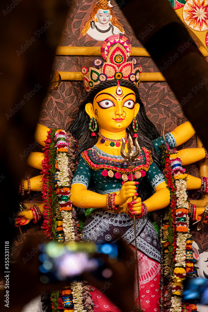 Blurred view of Goddess Devi Durga at a decorated puja pandal in Kolkata, West Bengal, India. Selective Focus