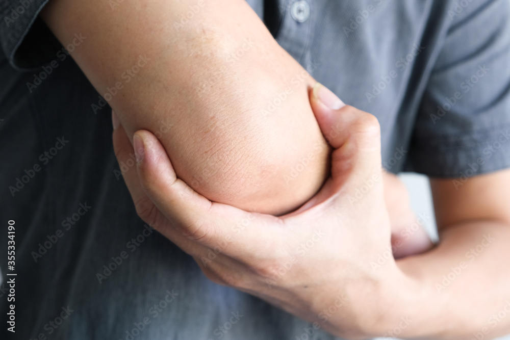 Men use their hands to hold their elbows and He had pain at the elbows.. Painful Health and medical concepts Men use their hands to hold their elbows and He had pain at the elbows.. Painful Health and medical concepts