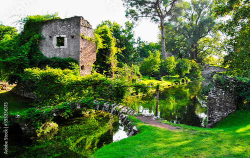 Garden of ninfa: detail of ruins and stone bridges on the river