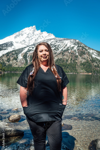 Woman nurse in black scrubs with a stethoscope in the mountains