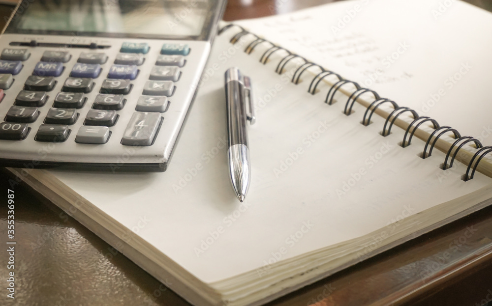 a Pen on a notebook with a Calculator a Pen on a notebook with a Calculator