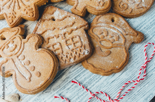 Homemade gingerbread cookies on tray on grunge gray wooden background. Christmas and New Year celebration background. Close up of home baked cookies with icing.