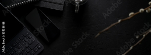 Dark modern concept workspace with digital devices, stationery, coffee cup and copy space © bongkarn