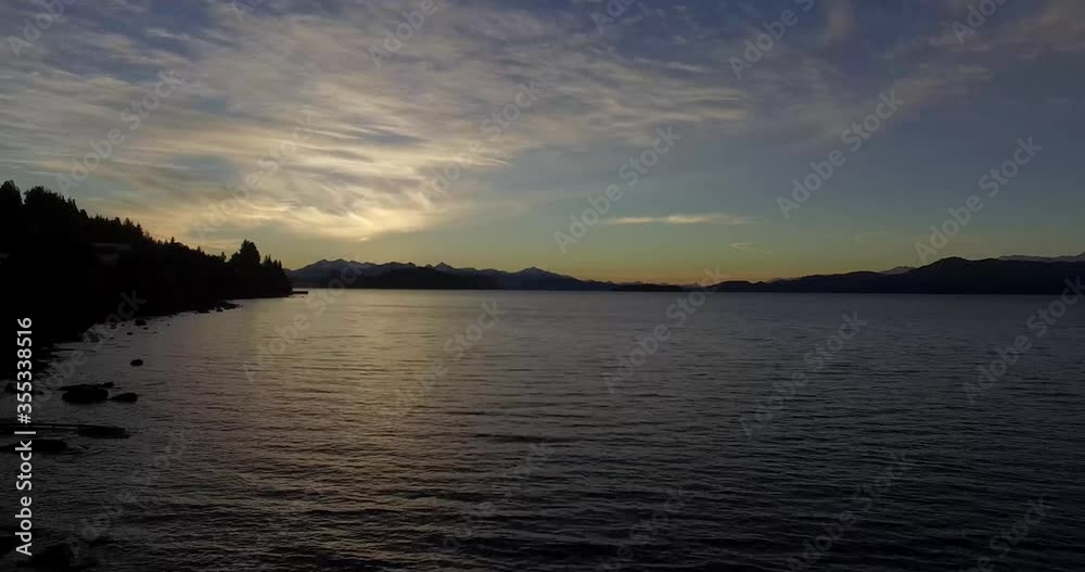 The sun above the mountain reflecting its yellow light on Lake Nahuel Huapi The sun above the mountain reflecting its yellow light on Lake Nahuel Huapi