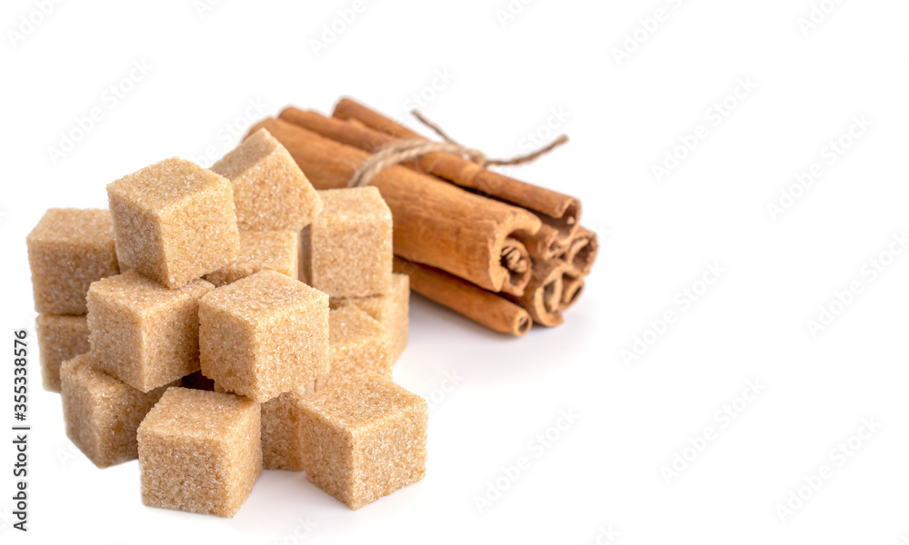 brown sugar cubes and cinnamon sticks on a white isolated background brown sugar cubes and cinnamon sticks on a white isolated background