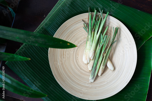 Fresh Lemongrass (Cymbopogon citratus) or citronella, serai on a wooden plate.
