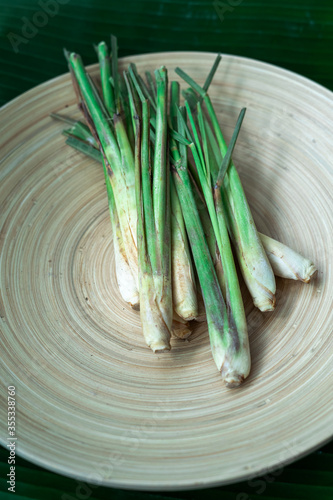 Fresh Lemongrass (Cymbopogon citratus) or citronella, serai on a wooden plate.