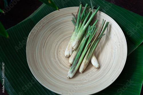 Fresh Lemongrass (Cymbopogon citratus) or citronella, serai on a wooden plate.