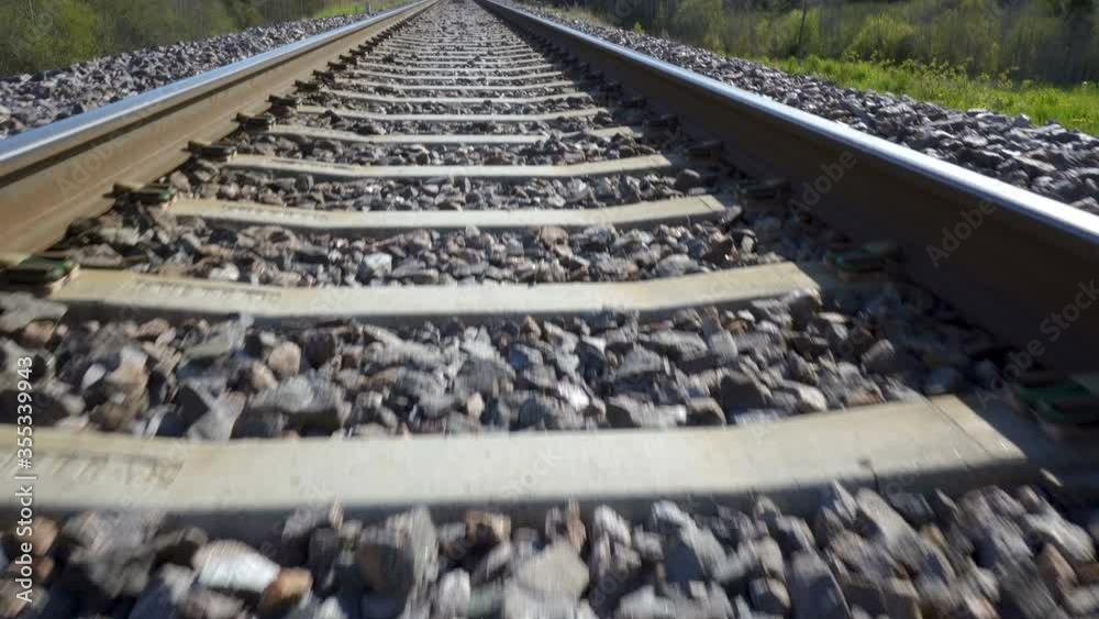 The small black rocks on the metal railroad track The small black rocks on the metal railroad track