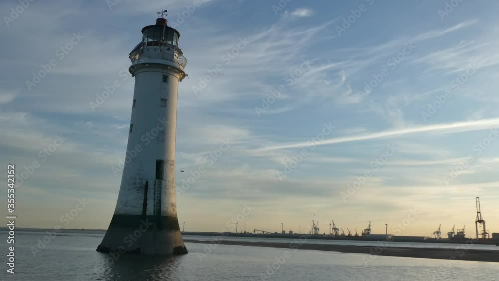 Landmark New Brighton Lighthouse beacon with Peel port on background skyline Landmark New Brighton Lighthouse beacon with Peel port on background skyline