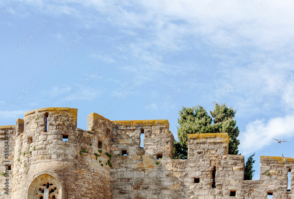 Battlement fortress wall with loopholes against the sky