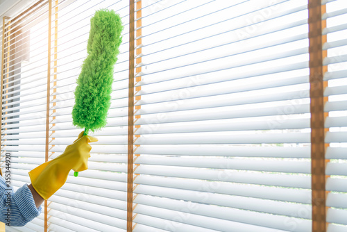 Photography Young female spring cleaning house interior holding a duster for wiping dust dusting furniture at home