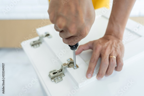 Technician Worker Fixing The Door Lock With Screwdriver in to wood. creating new things At Home, renovation and installing concept.