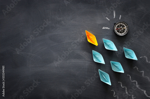 Konstfotografi Leadership banner concept with paper boat on blackboard background