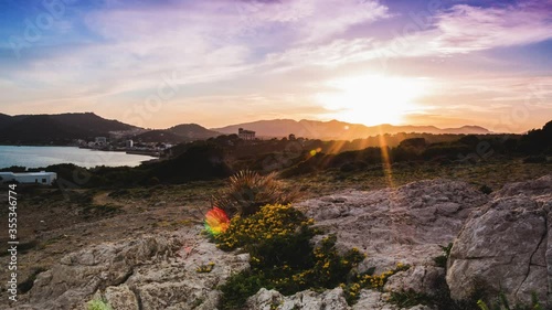 Breathtaking 4k sunset into the blue hour with dramatic moving red colorful clouds in Cala Ratjada Mallorca in Spain photo