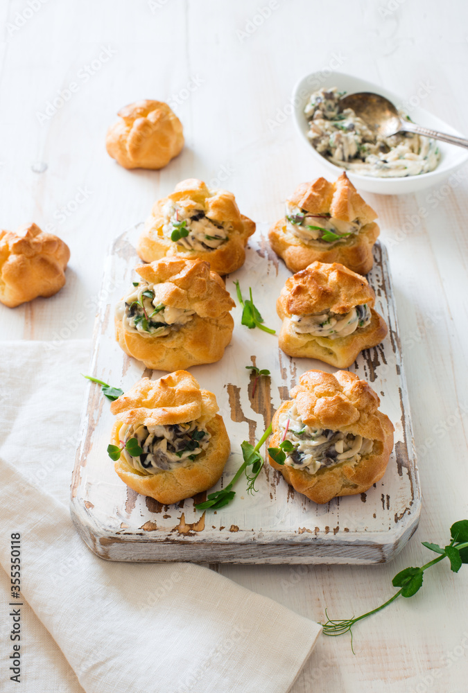 Profiteroles stuffed with cream cheese and mushrooms on white wooden background Profiteroles stuffed with cream cheese and mushrooms on white wooden background