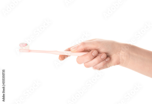 Female hand with toothbrush and paste on white background