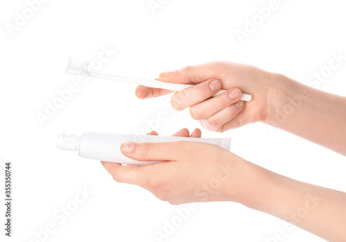 Female hands with toothbrush and paste on white background