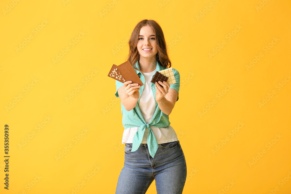 Beautiful young woman with tasty chocolate on color background Beautiful young woman with tasty chocolate on color background