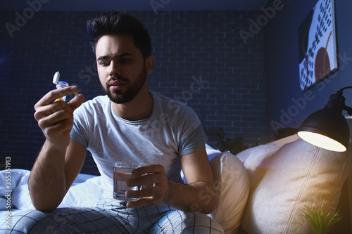 Man taking sleeping pills at night photo