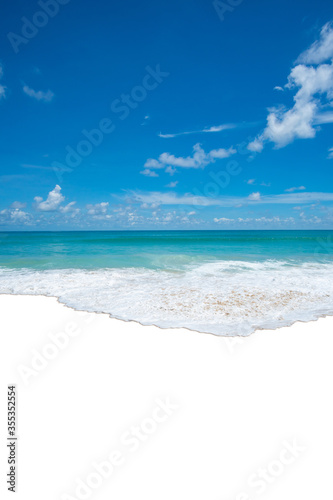 Seawater wave splash on sandy beach in summer day.