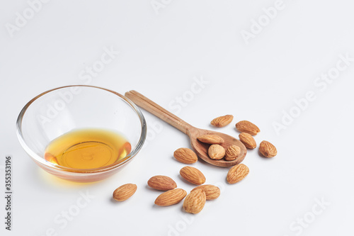almonds with a wooden spoon and honey in a piala on a white background. healthy food.