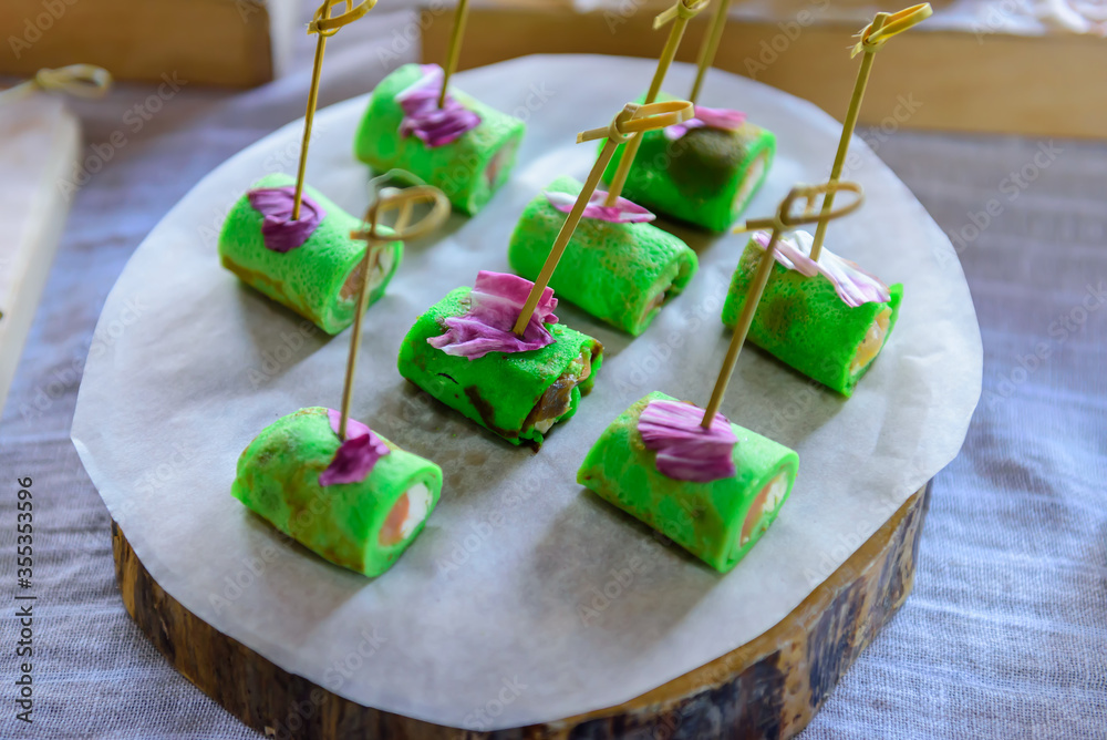 Φωτογραφία Cold appetizers in Japanese style in the form of rolls on skewers, on wooden tray, close-up