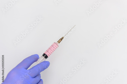 Close up hand in medical gloves holding syringe isolated on white background with copy space. Medicine and vaccination concept.