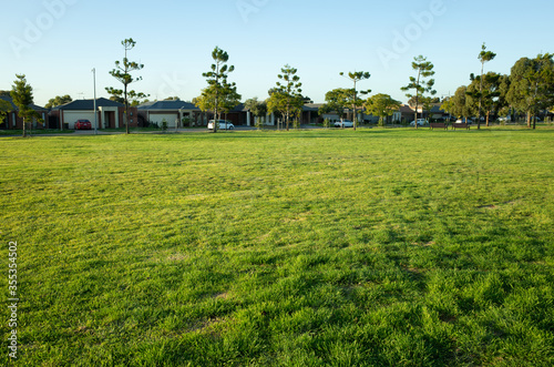 The green and healthy grass in a public park with a view of suburban houses in the background. Melbourne, VIC Australia.