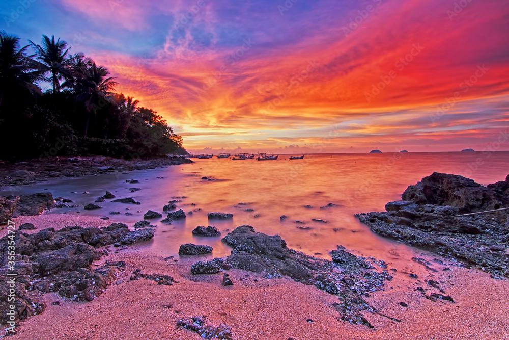 Naklejka premium Beautiful colours of sunset moment in Pulau Sayak, Kedah with high contrast and silhoutte effect. Soft focus effect due to long exposure technique