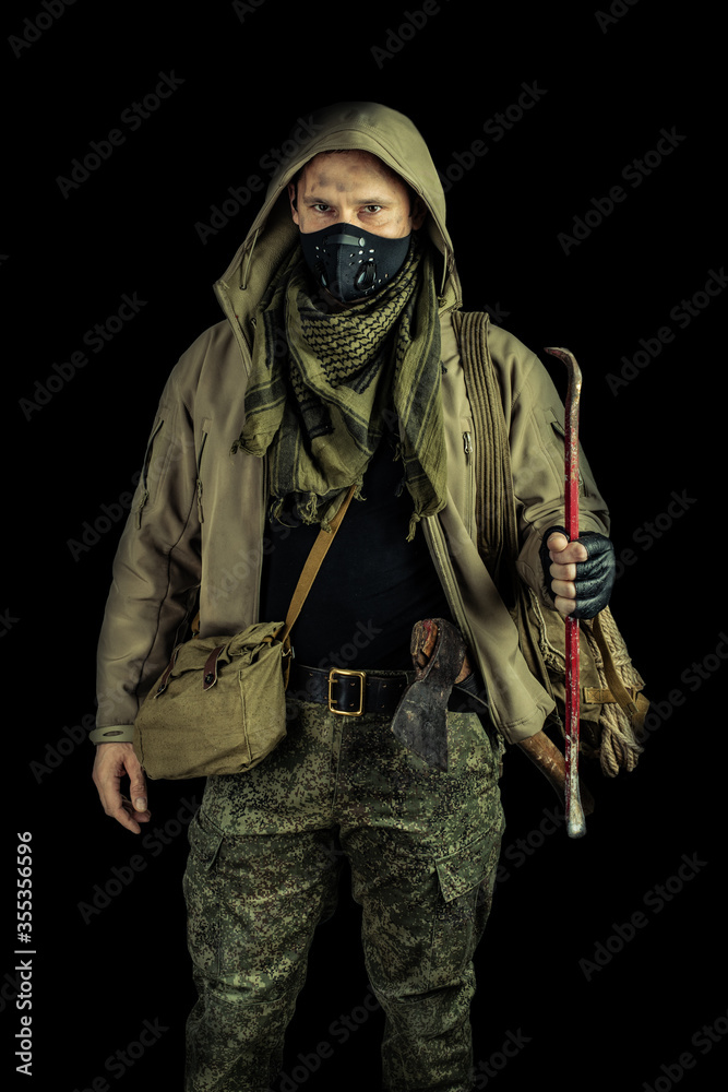 Fototapeta premium man with burglar crowbar wearing black protactive face mask and jacket with hood on black background