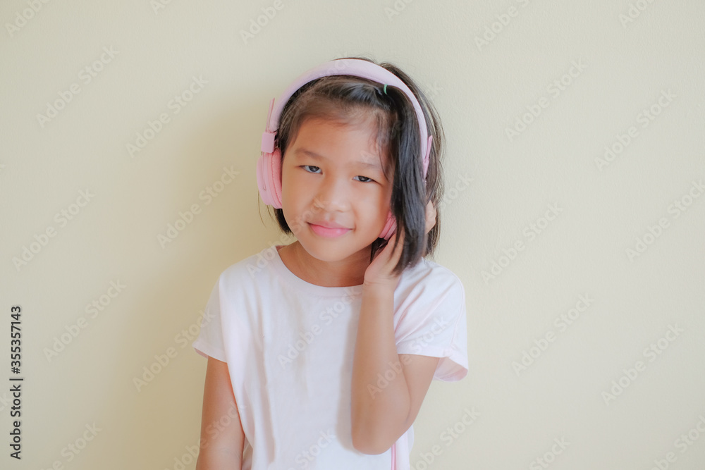 Portrait of young happy asian girl enjoying music with headphones on white background. Enjoy the sound concept. Portrait of young happy asian girl enjoying music with headphones on white background. Enjoy the sound concept.
