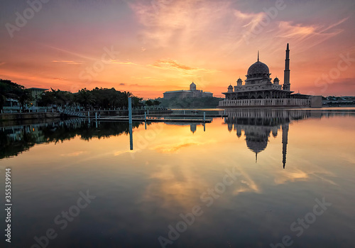 Beautiful sunrise view over Putrajaya with Putra Mosque and Putra Perdana Building as background with soft focus reflection effect