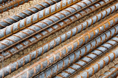 Closeup deformed bar. Rusty deformed bar on cement concrete flooring in construction site. Steel rods or reinforcing background. Rebar picture.