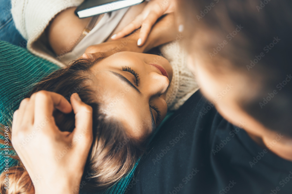 Close up photo of a caucasian woman with brown hair lying on her boyfriend - obrazy, fototapety, plakaty 