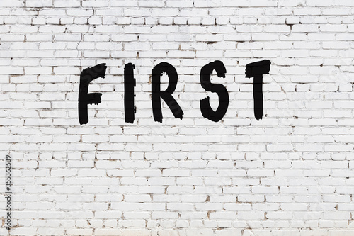 Word first painted on white brick wall