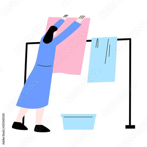 Young woman hanging clean colorful linens on weekday