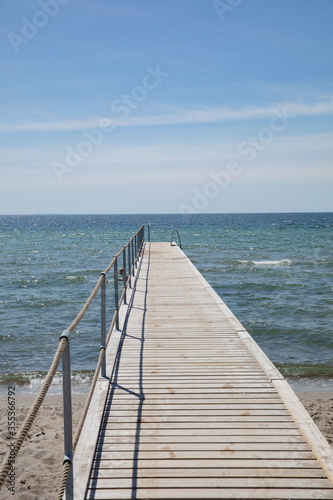 Bridge for bathing on the beach, blue sky  © mariahvid