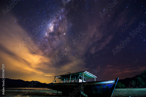 Amazing beautiful of night sky Milky Way Galaxy with abandon fisherman boat photo