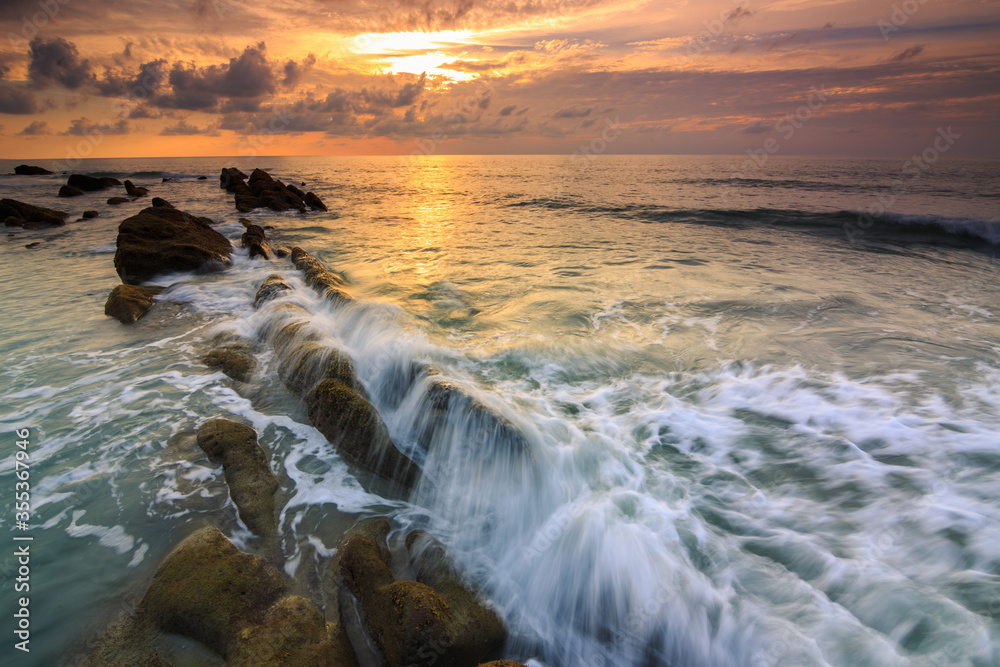 Fototapeta premium Amazing twilight Sunset seascape with sea wave hitting the green moss