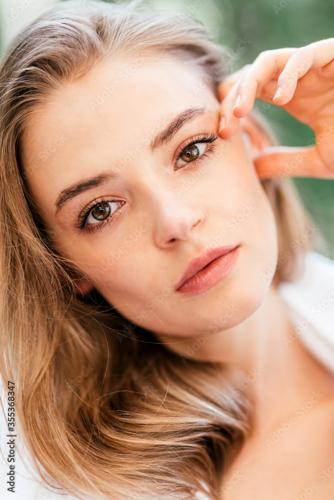 Fototapeta premium Beauty from within. Close-up portrait of a young beautiful caucasian woman with hazel eyes and light brown hair looking at camera with her piercing eyes while relaxing. Beauty concept. Vertical shot