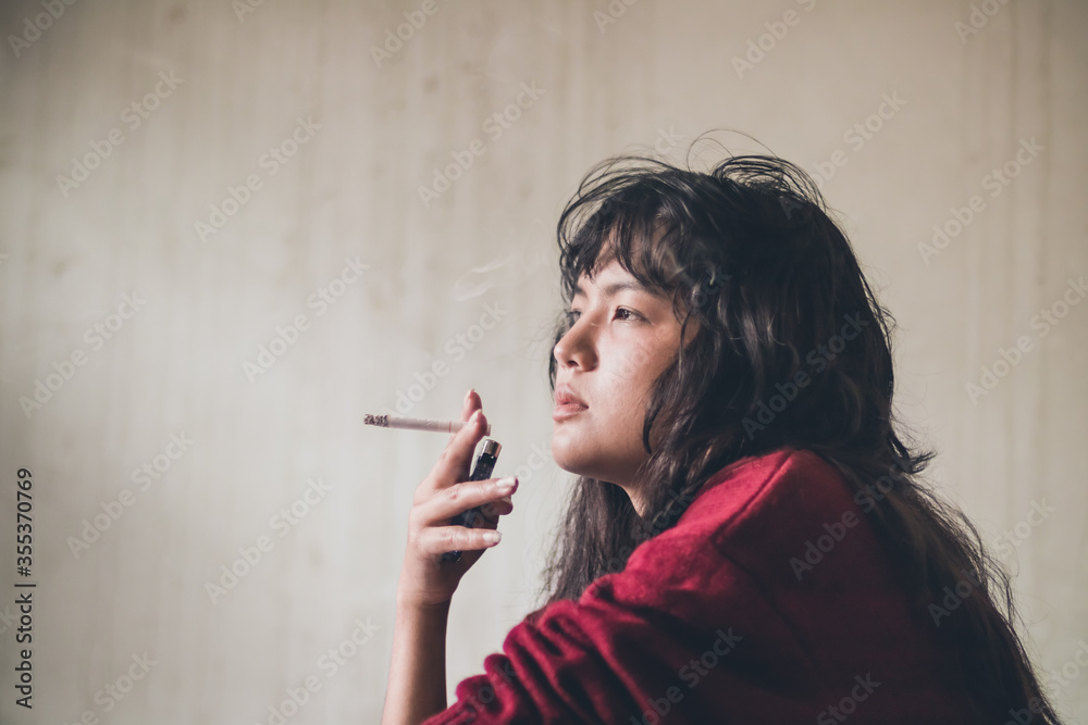 Obraz premium Stressed woman. A depressed woman smoking of stress Caused by social problems It's a concept about drugs and crime
