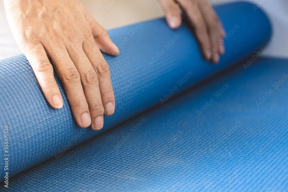 being rolled up by hand blue yoga mat after exercise being rolled up by hand blue yoga mat after exercise