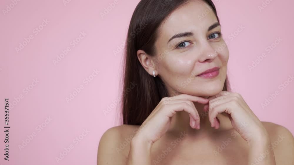 Portrait woman with bare shoulders posing on camera isolated on pink background Portrait woman with bare shoulders posing on camera isolated on pink background