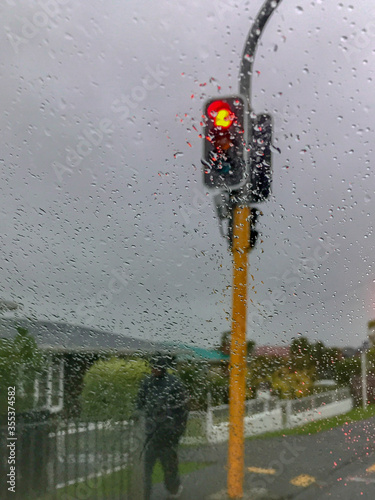 Man walking under traffic light in the rain