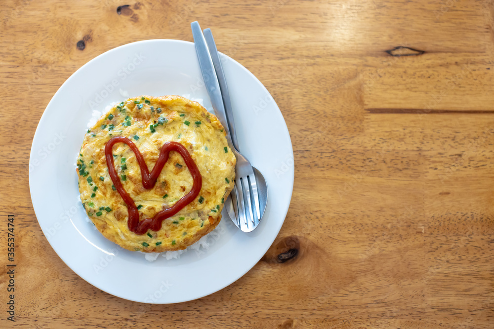 
Omelette on a white plate with red heart-shaped sauce