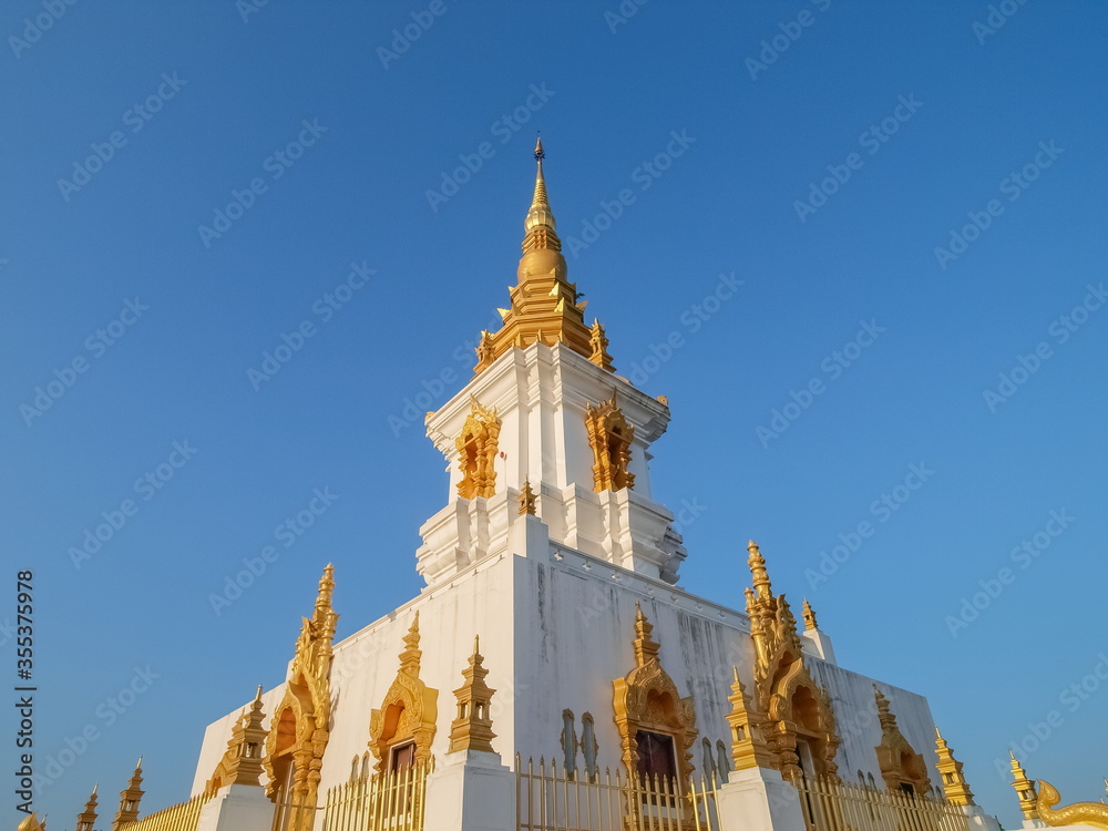 Obraz premium view of white Chedi Tian Yok (white pagoda) with blue sky background, Wat Phumi Pharam, Chiang Rai, northern of Thailand.