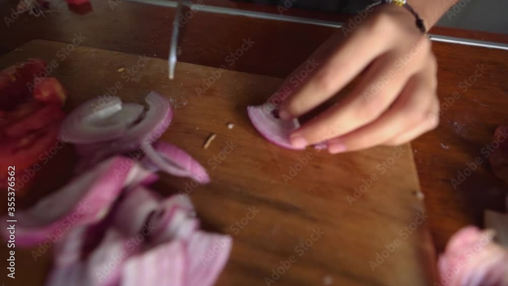 Woman hand Using Knife And Cutting Onion On Wooden Cutting Board Woman hand Using Knife And Cutting Onion On Wooden Cutting Board